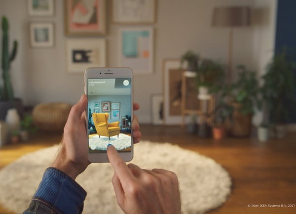 Man holding smart phone with yellow formal chair - superimposed over an apartment background