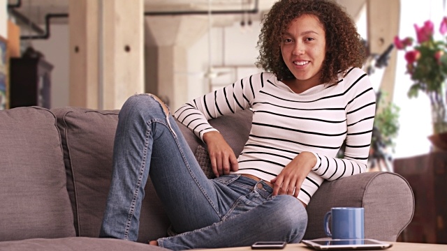 Woman in stripe shirt hanging out on the couch