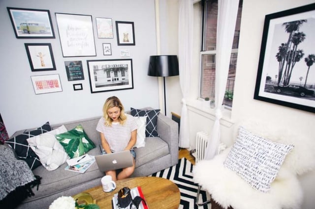 Woman on laptop in apartment on couch
